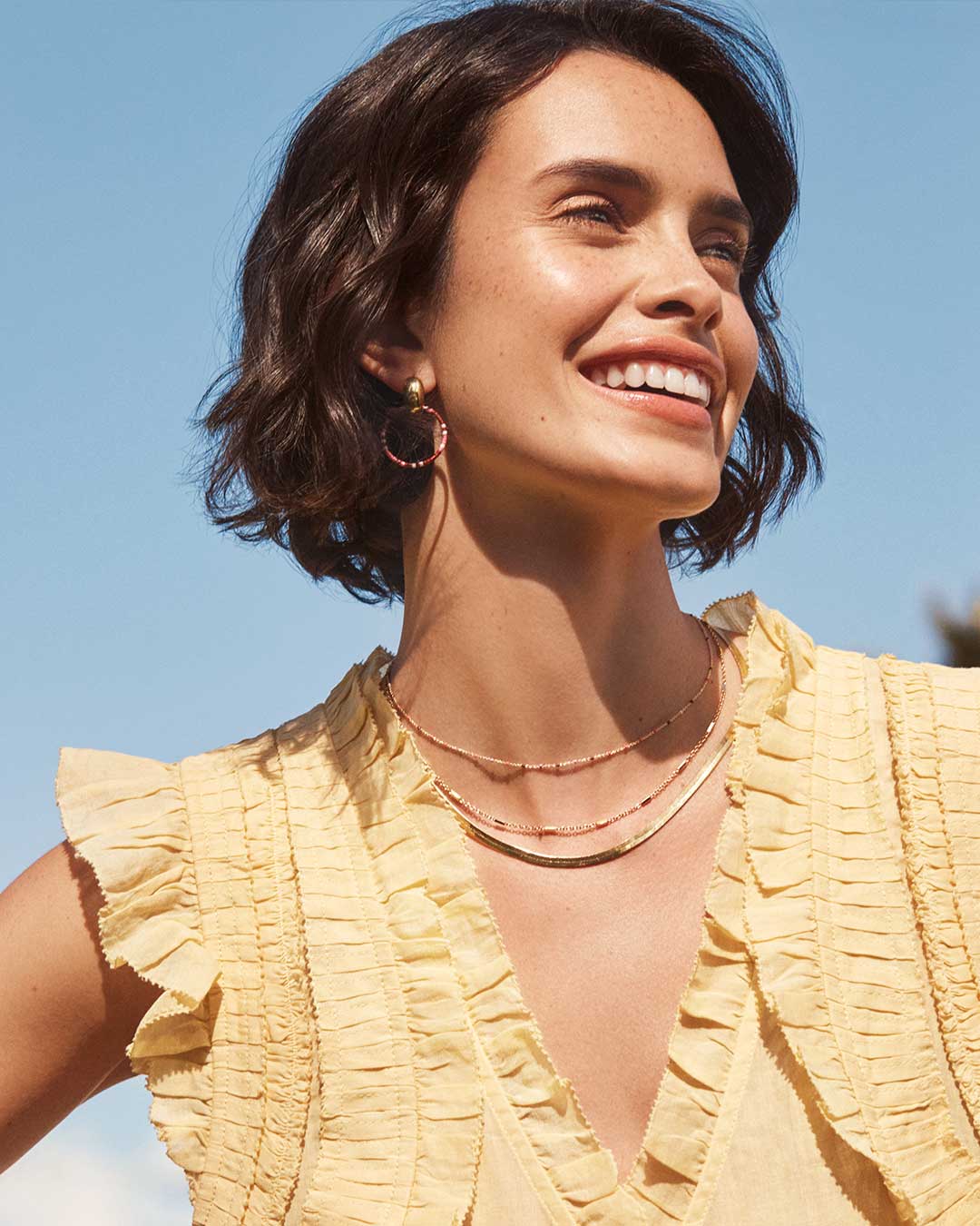 woman in yellow shirt layered necklace